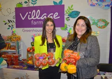 Krysten DeGiglio and Helen Aquino with Village Farms show a clamshell with 6 ct. beefsteak tomatoes and a bag with sweet bell peppers.